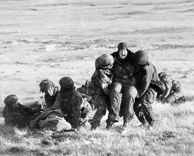 File photo dated 04/06/82 of British paratroopers carrying out emergency medical treatment on wounded comrades while under fire on Mount Longdon during the Falklands war.