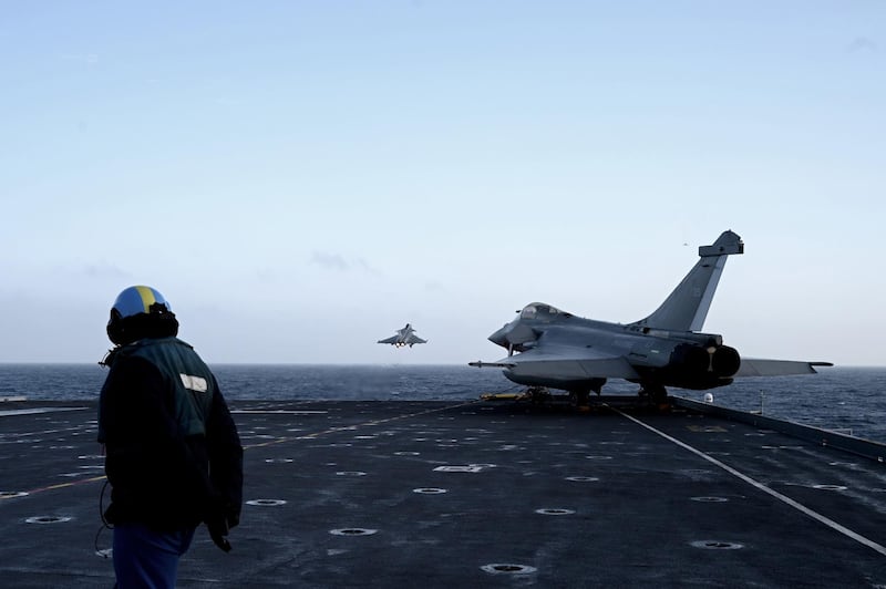 epa08155279 A military staff looks at Rafale jet fighters taking off from the French aircraft carrier Charles de Gaulle at sea, off the coast of the city of Hyeres, France, 23 January 2020.  EPA/PHILIPPE LOPEZ / POOL MAXPPP OUT