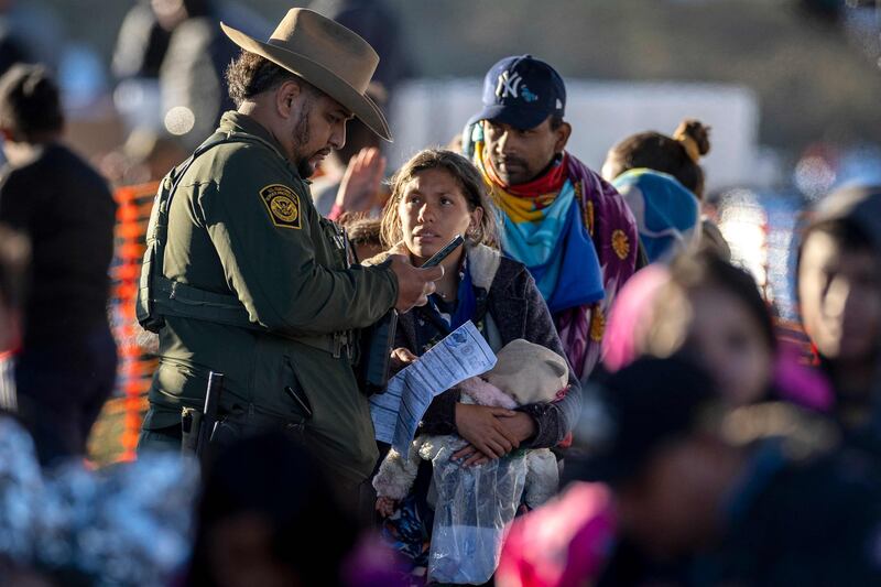 A US Border Patrol agent speaks with migrants at a transit centre near the Mexican border in Eagle Pass, Texas. Getty Images / AFP