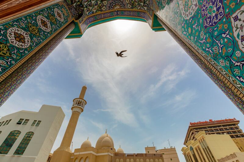 A bird flies between two mosques in Bur Dubai. Chris Whiteoak / The National