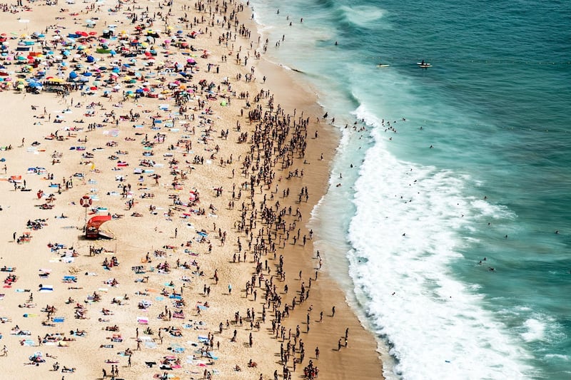 epa06924048 People rest on the Nazare beach, in Nazare, center of Portugal, center of Portugal, 02 August 2018. The Portuguese Institute of the Sea and Atmosphere (IPMA), warns that the maximum temperatures will be 'well above the normal values for the time, close to 40 degrees Celsius as a spell of heat weather is going through Europe.  EPA/PAULO CUNHA