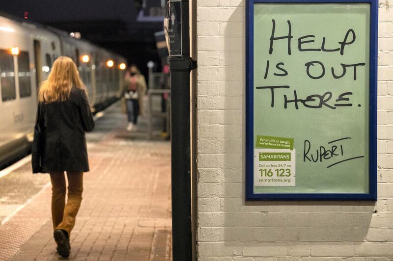 A female rail traveller walks along the platform at Loughborough Junction railway station where a Samaritan's poster urges those with mental health issues, or even thoughts of suicide, to seek help from the registered charity aimed at providing emotional support to anyone in emotional distress, struggling to cope, or at risk of suicide throughout the United Kingdom and Ireland, often through their telephone helpline, on 27th February 2021, in London, England. (Photo by Richard Baker / In Pictures via Getty Images)