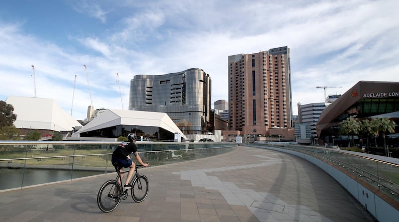 ADELAIDE, AUSTRALIA - NOVEMBER 20: A cyclist rides over the Torrens footbrdige on November 20, 2020 in Adelaide, Australia. South Australian premier Steven Marshall has eased lockdown restrictions across the state, after initially imposing a strict six day lockdown on Thursday following an outbreak of COVID-19 in the community. Effective today, restrictions have eased to allow people to leave their homes for exercise, and as of midnight on Saturday current stay at home orders will be repealed. (Photo by Kelly Barnes/Getty Images)