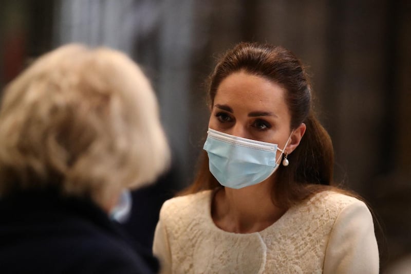 Britain's Catherine, Duchess of Cambridge (R) speaks to health workers as she visits the coronavirus vaccination centre at Westminster Abbey, central London on March 23, 2021, to pay tribute to the efforts of those involved in the Covid-19 vaccine rollout.   / AFP / POOL / Aaron Chown
