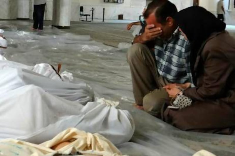A Syrian couple mourn in front of bodies wrapped in shrouds ahead of funerals following a toxic gas attack in Eastern Ghouta on the outskirts of Damascus.