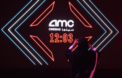 A Saudi man takes a picture of the AMC logo during a cinema test screening in Riyadh on April 18, 2018.
Blockbuster action flick "Black Panther" play at a cinema test screening in Saudi Arabia on April 18, the first in a series of trial runs before movie theatres open to the wider public next month. The conservative kingdom lifted a 35-year ban on cinemas last year as part of a far-reaching liberalisation drive, with US giant AMC Entertainment granted the first licence to operate movie theatres. / AFP PHOTO / Fayez Nureldine