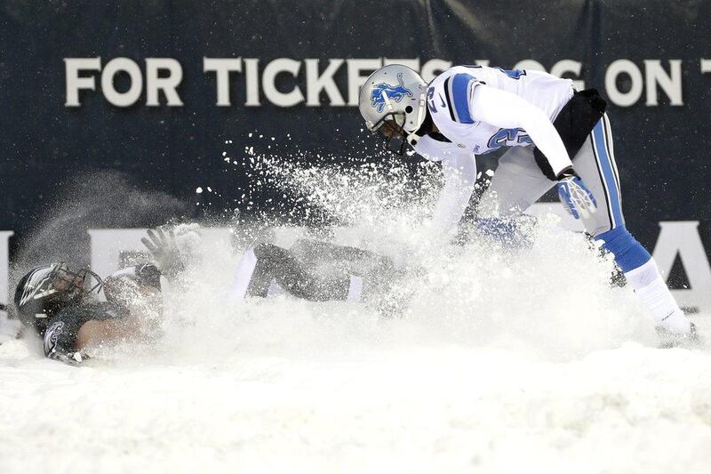 Philadelphia's Riley Cooper, left, falls into the snow next to Detroit's Chris Houston on Sunday. Matt Rourke / AP