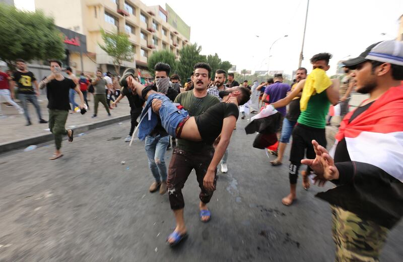 Iraqi protesters carry away a wounded man.  EPA