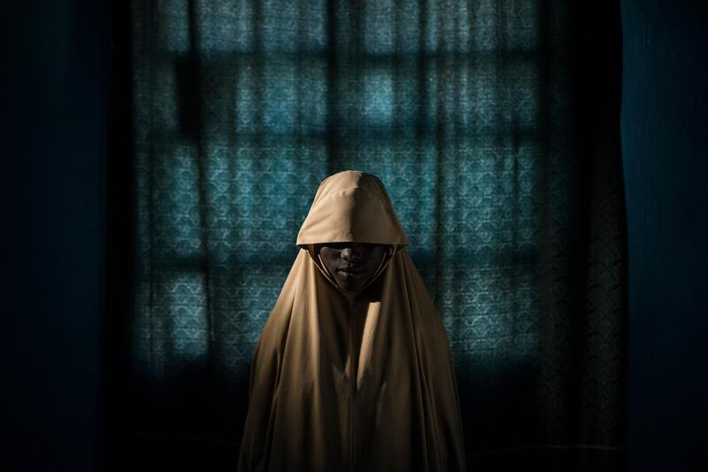 Adam Ferguson took first place in the 'People - Stories' category. This picture from the story shows Aisha, age 14, standing for a portrait in Maiduguri, Borno State, Nigeria. She was kidnapped by Boko Haram then assigned a suicide bombing mission. After she was strapped with explosives, she found help instead of blowing herself and others up.  EPA/ADAM FERGUSON/NEW YORK TIMES