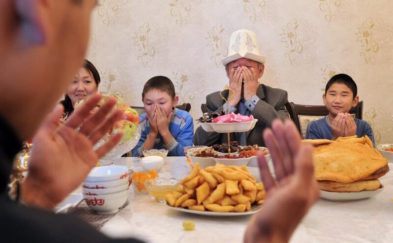 A family in in the village of Kok-Zhar, Kyrgyzstan, pray before a meal on the first day of the Eid Al Adha.