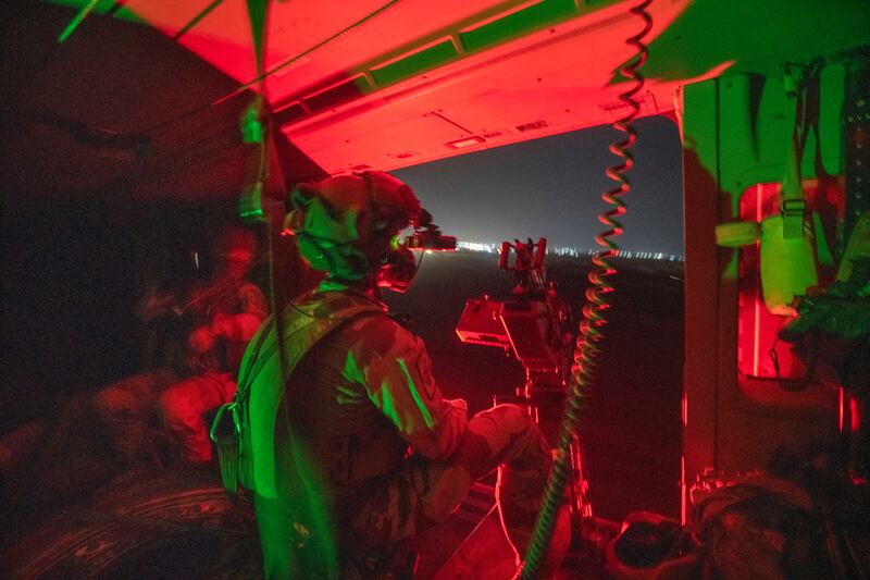 A French Barkhane force soldier mans a machine gun on board a Caiman transport helicopter during a night mission in Gao, Mali. AP Photo