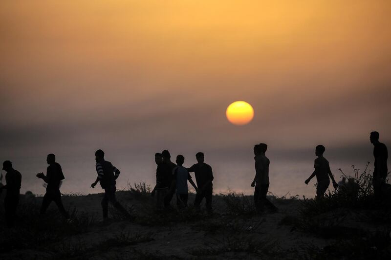 Protesters silhouetted against the setting sun during clashes near the border between Israel and the Gaza Strip. EPA