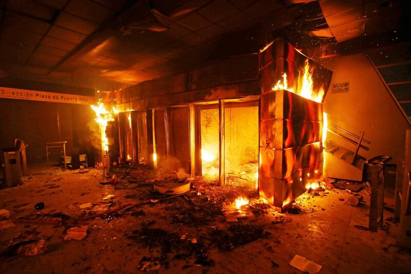 A subway ticket office is seen on fire during a protest against the increase in the subway ticket prices in Santiago, Chile. Reuters
