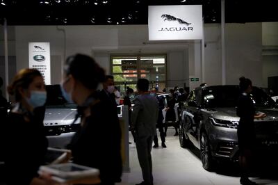 FILE PHOTO: People wear face masks following the coronavirus disease (COVID-19) outbreak, at the Jaguar Land Rover's booth at the Beijing International Automotive Exhibition, or Auto China show, in Beijing, China September 27,  2020. REUTERS/Tingshu Wang/File Photo