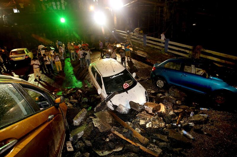 Bystanders look at one of the many destroyed vehicles. EPA