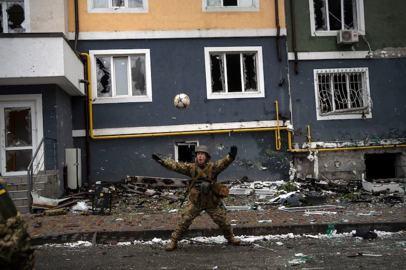 A Ukrainian soldier during a pick-up game of football in Irpin in April 2022