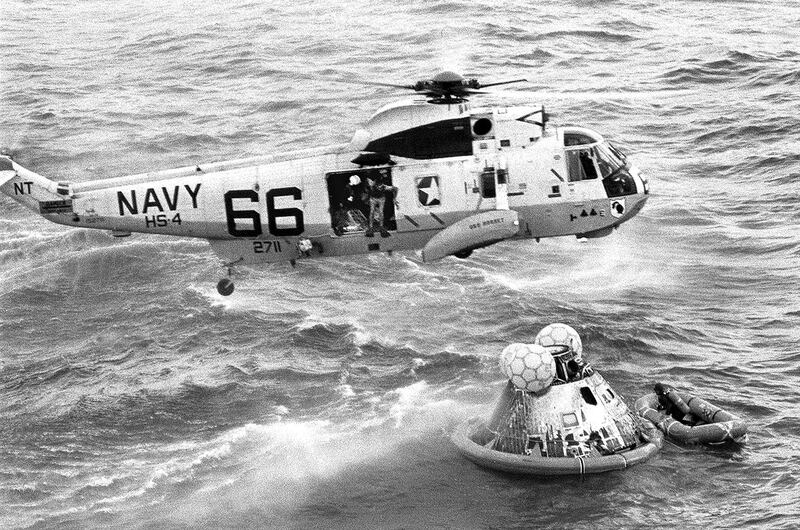 Navy UDT swimmer Clancy Hatleberg prepares to jump from a helicopter to assist the astronauts into the raft at right. US Navy / AP