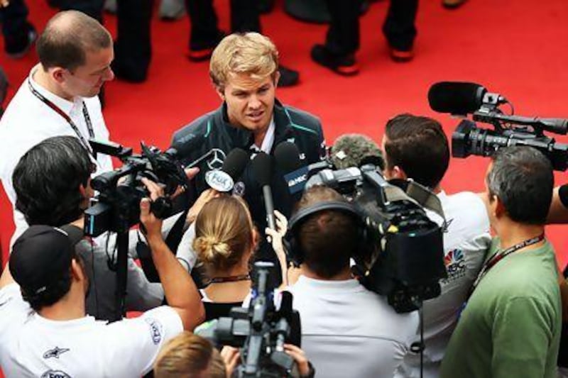Mercedes GP’s German driver Nico Rosberg is mobbed by members of the media yesterday.