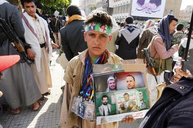 A Yemeni child displays posters of Houthi leaders for sale in Sana'a, Yemen. EPA