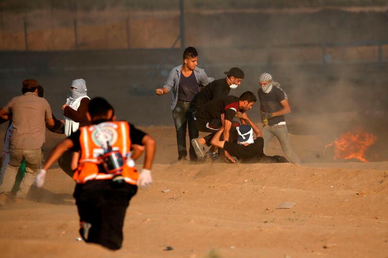 Palestinian paramedics help a protester at the Israel-Gaza border, east of Gaza city, on October 12, 2018. AFP
