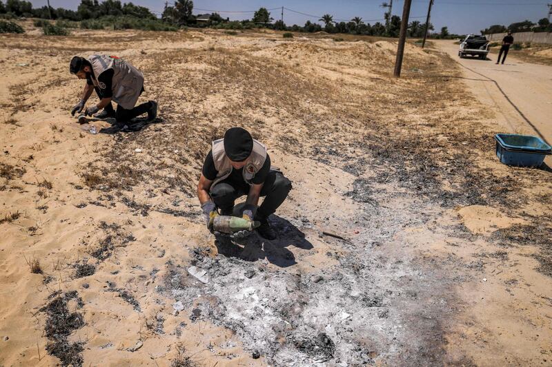 Explosives experts from Hamas retrieve unexploded projectiles from a field in Khan Yunis in the southern Gaza Strip. AFP