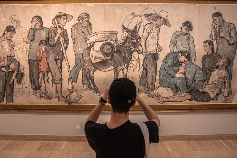 A man takes a photo of a work on display as part of the 'A tribute to donors' exhibition at the National Art Museum of China.  EPA
