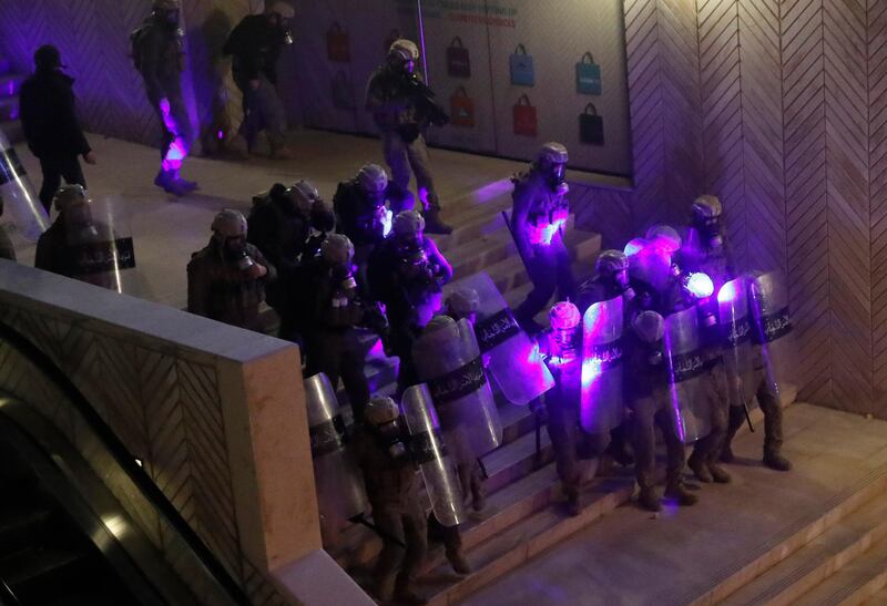 Special forces police are illuminated by laser pointers from anti-government protesters. AP Photo