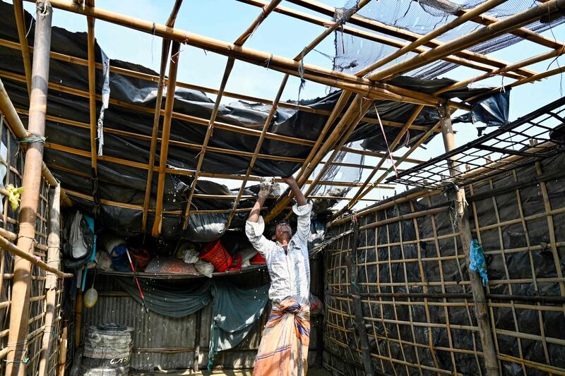 A Shahporir islander makes repairs to his house roof, which was destroyed by the cyclone. AFP