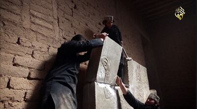 ISIS militants pictured destroying a stoneslab with a sledgehammer at the ancient Assyrian city of Nimrud in northern Iraq. AFP
