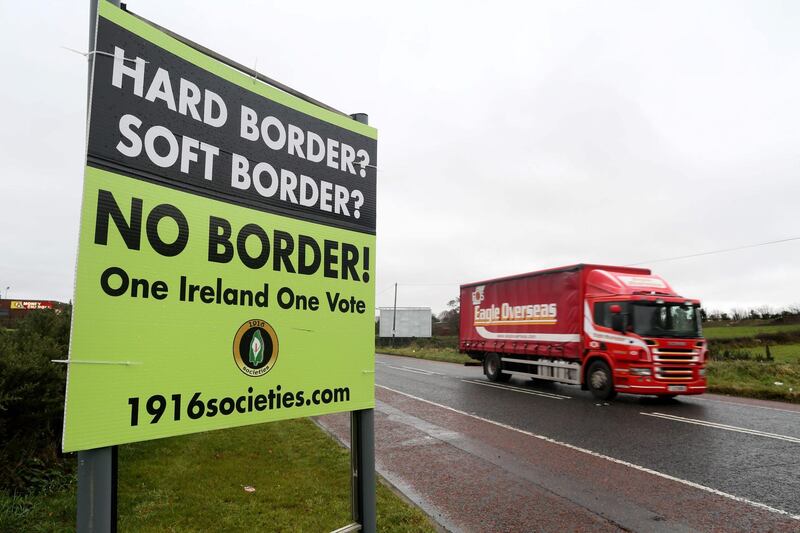 (FILES) In this file photo taken on November 14, 2018, aA lorry passes a post-Brexit anti-border poster, outside Newry, Northern Ireland, near the border with Ireland.  Preparedness in Britain for a no-deal Brexit remains "at a low level", with logjams at Channel ports threatening to impact drug and food supplies, according to government assessments released September 11, 2019. Britain's plan for no checks at the Irish border would likely "prove unsustainable due to significant economic, legal and biosecurity risks", it said, adding that it could lead to a black market developing in border communities, with dissident groups expected to capitalise. Gibraltar could be particularly badly affected, it said, due to the imposition of checks at its border with Spain. / AFP / Paul FAITH
