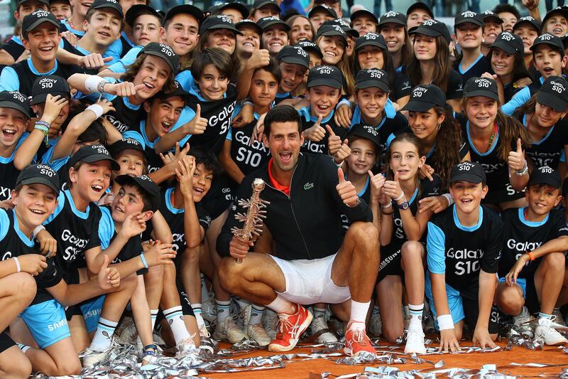 Novak Djokovic of Serbia celebrates with the winners trophy next to the ball boys and girls after defeating Stefanos Tsitsipas of Greece in the final during day nine of the Mutua Madrid Open. Getty Images