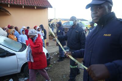 People gather at the Enyobeni Tavern in East London, South Africa, where at least 20 young people died from undetermined causes. EPA