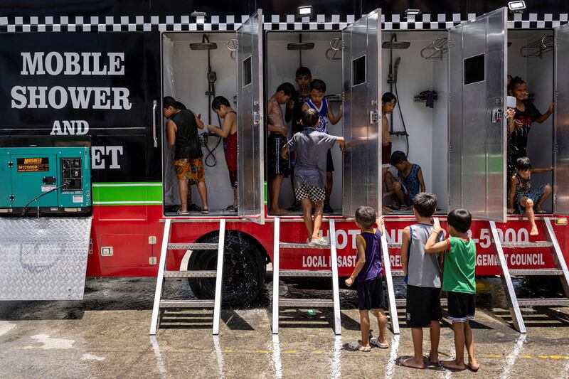 Children use a mobile shower provided by the local government, amid a heatwave in Valenzuela, Philippines. Reuters