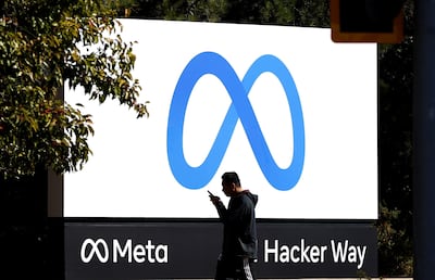 A pedestrian walks in front of a new logo and the name 'Meta' on the sign in front of Facebook headquarters in Menlo Park, California. AFP
