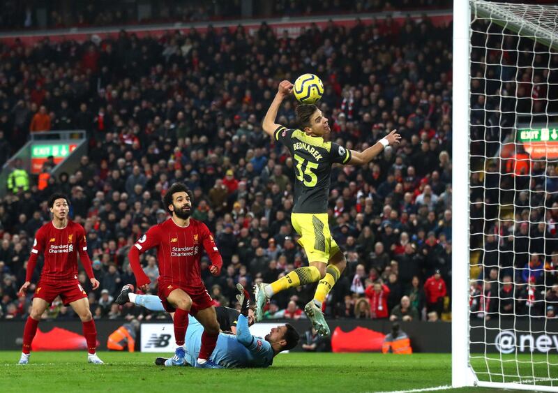 LIVERPOOL, ENGLAND - FEBRUARY 01: Mohamed Salah of Liverpool scores his team's fourth goal past Alex McCarthy as he is challenged by James Ward-Prowse of Southampton during the Premier League match between Liverpool FC and Southampton FC at Anfield on February 01, 2020 in Liverpool, United Kingdom. (Photo by Julian Finney/Getty Images)