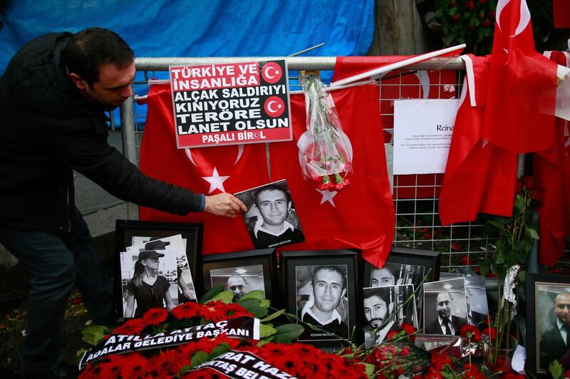 FILE - In this Wednesday, Jan. 4, 2017 file photo, a man adjusts a victim's photograph displayed with floral tributes and Turkish flags, outside the Reina night club following the New Year's day attack, in Istanbul. A Turkish court has on Monday, Sep. 7, 2020 sentenced an Islamic State militant to life in prison over the New Yearâ€™s Eve attack on a nightclub in Istanbul that left 39 people dead in 2017. Albulkadir Masharipov of Uzbekistan was charged with membership in a terror group, murder and attempting to overthrow the constitutional order, among other charges. (AP Photo/Emrah Gurel, file)