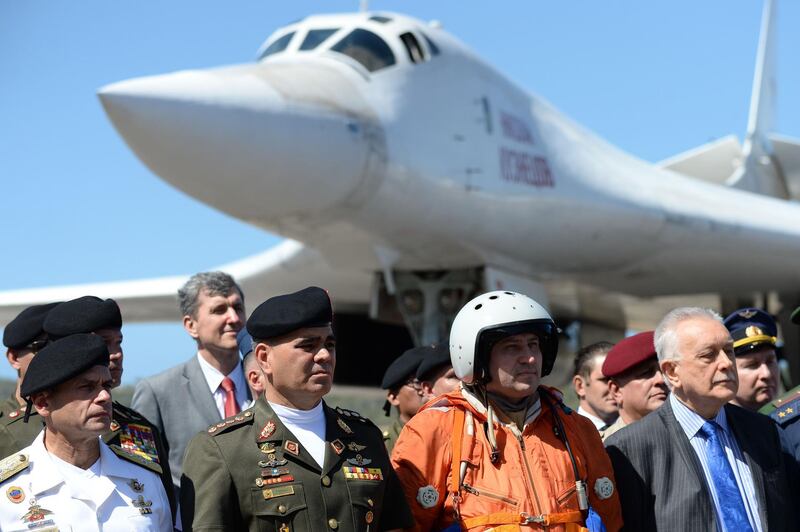 Venezuelan Defence Minister Vladimir Padrino (2-L) is pictured after the arrival of two Russian Tupolev Tu-160 strategic long-range heavy supersonic bomber aircrafts at Maiquetia International Airport, just north of Caracas, on December 10, 2018. Venezuela and Russia will hold joint air force exercises for the defence of the South American country, Padrino announced on Monday. Padrino welcomed about 100 Russian pilots and other personnel after the Tu-160s and two other aircraft landed at the international airport that serves Caracas. / AFP / Federico PARRA
