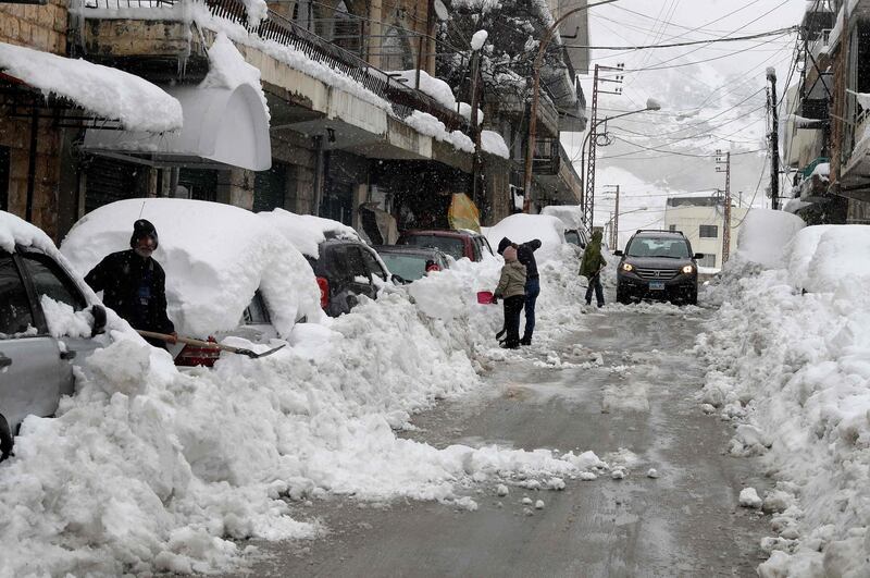 People shovel snow in front of their shops and houses in the town of Bcharre in Mount Lebanon. AFP