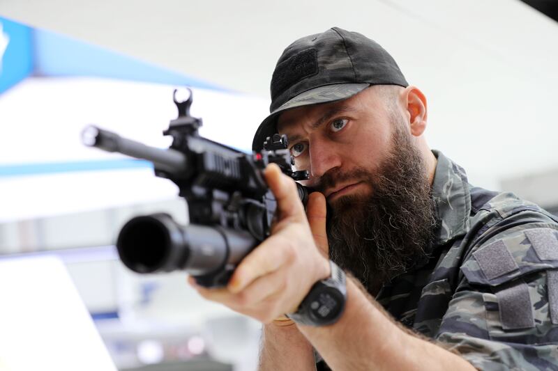 Social media personality Marat Sutaev looks at an under-barrel grenade launcher at Idex