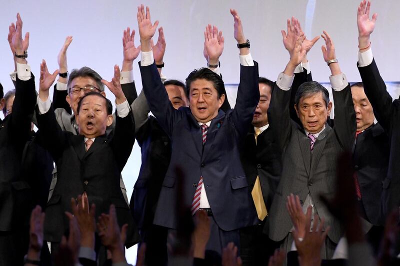 (FILES) In this file photo taken on March 25, 2018 Japan's Prime Minister and ruling Liberal Democratic Party (LDP) leader Shinzo Abe (C) leads 'Banzai' shouts at the end of his party convention in Tokyo. Japan's Shinzo Abe became the country's longest-serving premier on November 20, 2019, but many of his ambitious goals, including a constitutional revision to strengthen the military, appear far from reach. / AFP / Toshifumi KITAMURA
