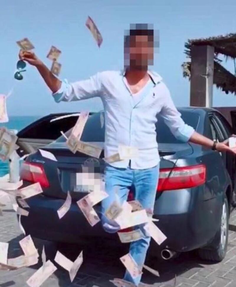 A man has been arrested by Dubai Police after posting footage of himself throwing a pile of money on social media. Courtesy Dubai Police
