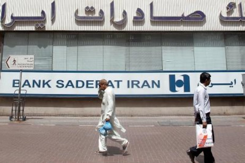 People walk past Bank Saderat Iran on May 19, 2010 in Dubai, one of the Islamic republic's top trading partners. Iran has voiced exasperation at US-led international rejection of a hard-won nuclear fuel deal, saying major powers would be "discrediting" themselves if they pressed for fresh UN sanctions. The new draft resolution before the Security Council would expand an arms embargo and measures against Iran's banking sector, as well as banning it from sensitive overseas activities, like uranium mining and developing ballistic missiles, a US official said.    AFP PHOTO/KARIM SAHIB *** Local Caption ***  560147-01-08.jpg
