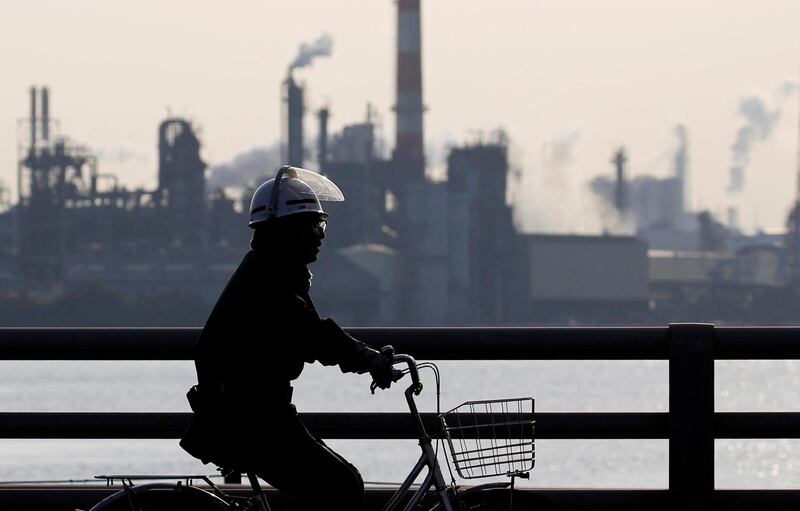 FILE PHOTO: A worker cycles near a factory at the Keihin industrial zone in Kawasaki, Japan, November 15, 2017.  REUTERS/Toru Hanai/File Photo