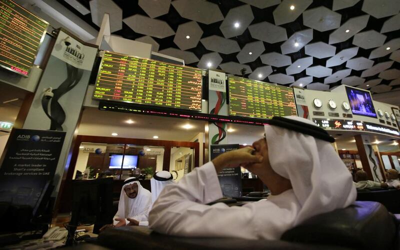Investors follow screens at the Dubai Financial Market. Ali Haider / EPA