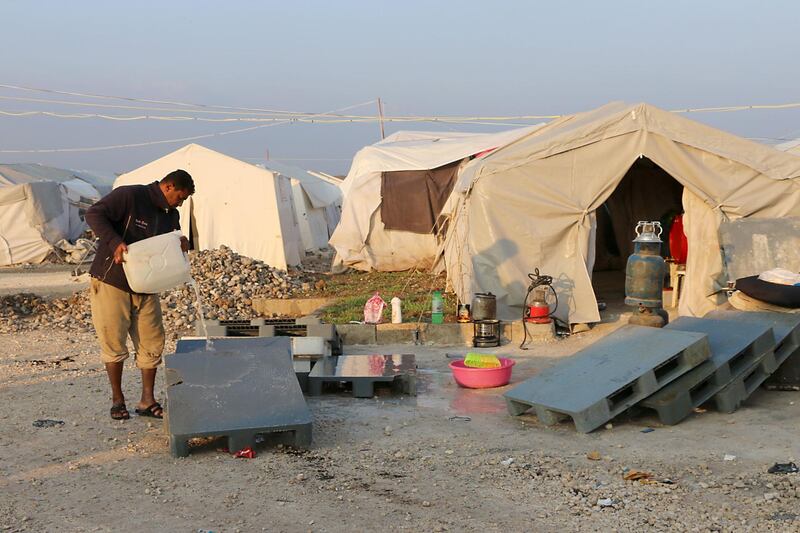 A displaced man from Yarmuk washes a plastic pallet in the Deir al-Ballut refugee camp in Afrin's countryside. AFP