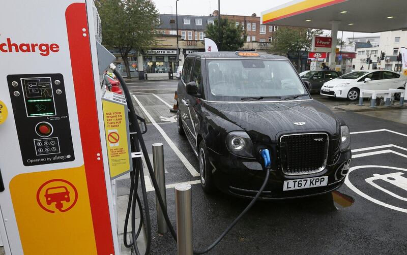 FILE - In this file image dated Wednesday Oct. 18, 2017, 2017, a new TX Cab London taxi is plugged into a charging station in London.  Londonâ€™s black cabs will be seen on the streets of Paris next year as the London Electric Vehicle Company has announced Thursday Oct. 18, 2018, that they will begin selling its wares in the City of Light. (AP Photo/Tim Ireland, FILE)