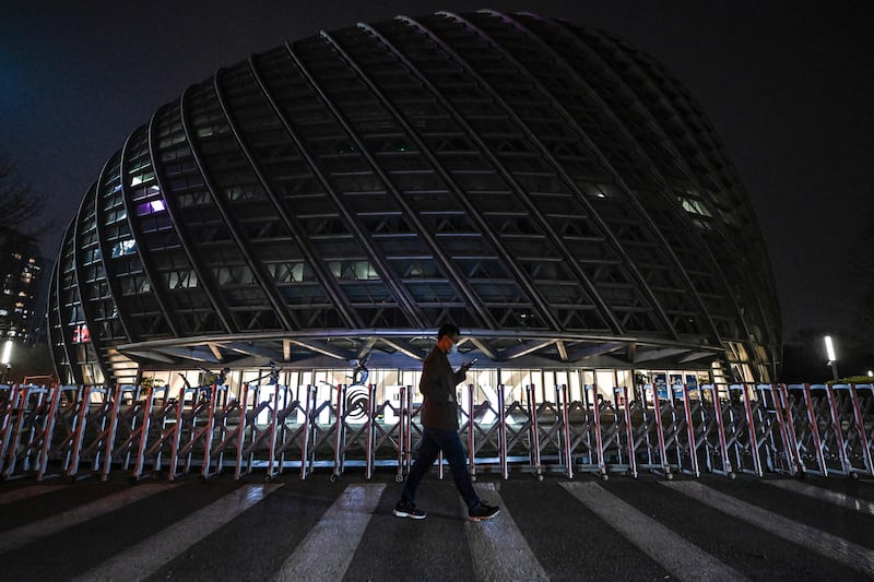 A man walks past the Phoenix Center after its lights are turned off for the Earth Hour environmental campaign in Beijing. AFP