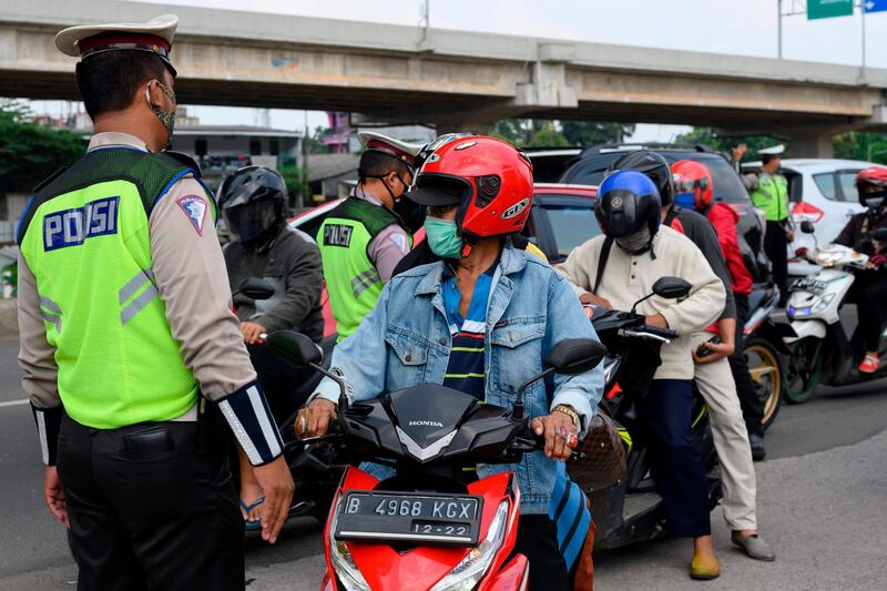 Indonesian officials check the documents of motorists leaving Jakarta.  AFP