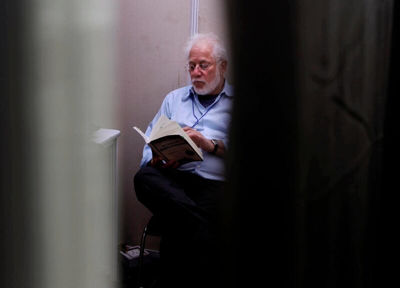 FILE - In this file photo dated Friday, Jan. 20, 2012, Sri Lankan-born Canadian novelist, poet and Booker Prize-winner Michael Ondaatje reads a book at the back stage green room before presenting his talk at the Jaipur Literature Festival, in Jaipur, in the western Indian state of Rajasthan.  Organizers of the Man Booker Prize announced the long list Tuesday July 24, 2018, including Ondaatje for his latest novel â€œWarlight,â€ (AP Photo/ Manish Swarup, FILE)