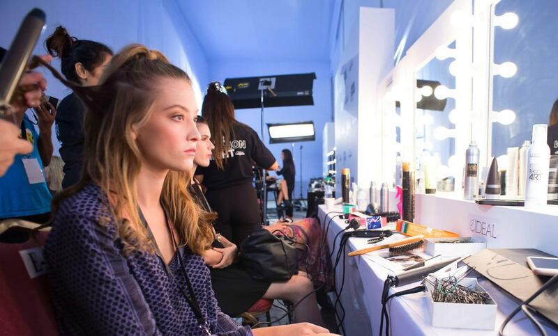 A model has her hair tended to backstage at Kage at Fashion Forward. Courtesy Getty Images